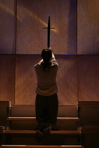 A man kneeling in prayer beneath a cross, Book of Days
