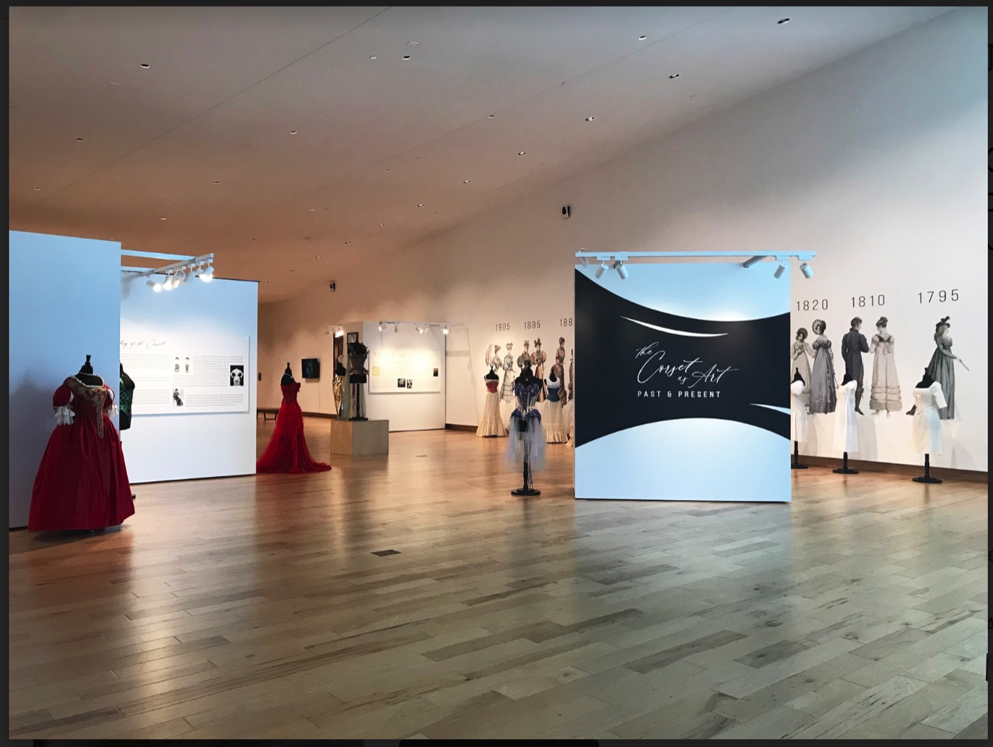Exhibition entryway with historical gowns, The Corset as Art, SUMA