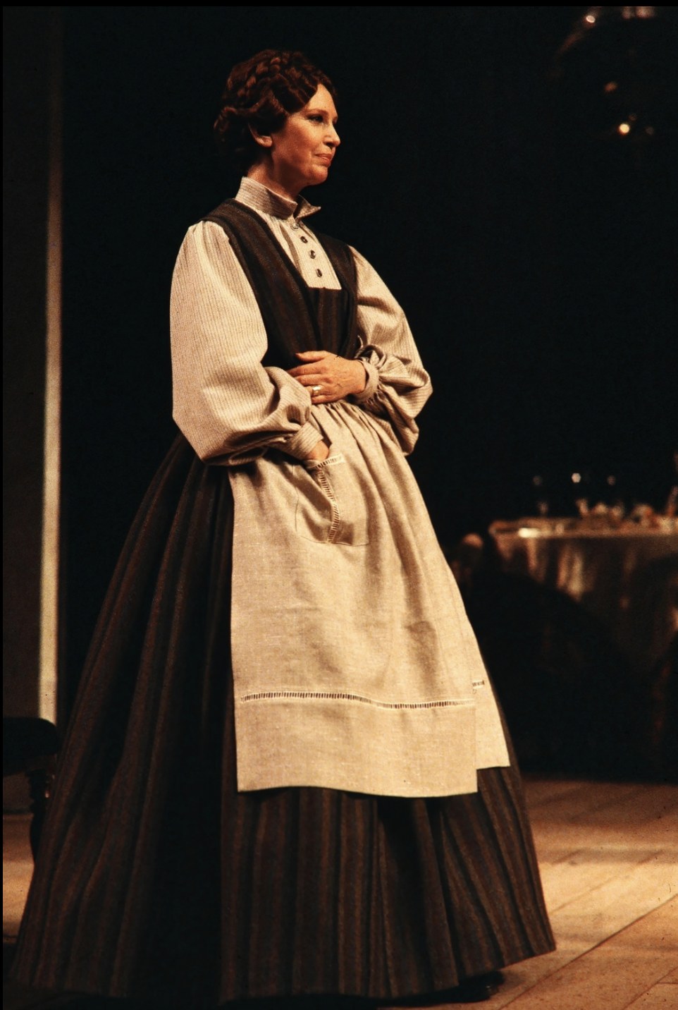 Woman in a pale apron over a dark skirt, An Enemy of the People, Seattle Repertory Theatre, costumes by Laura Crow