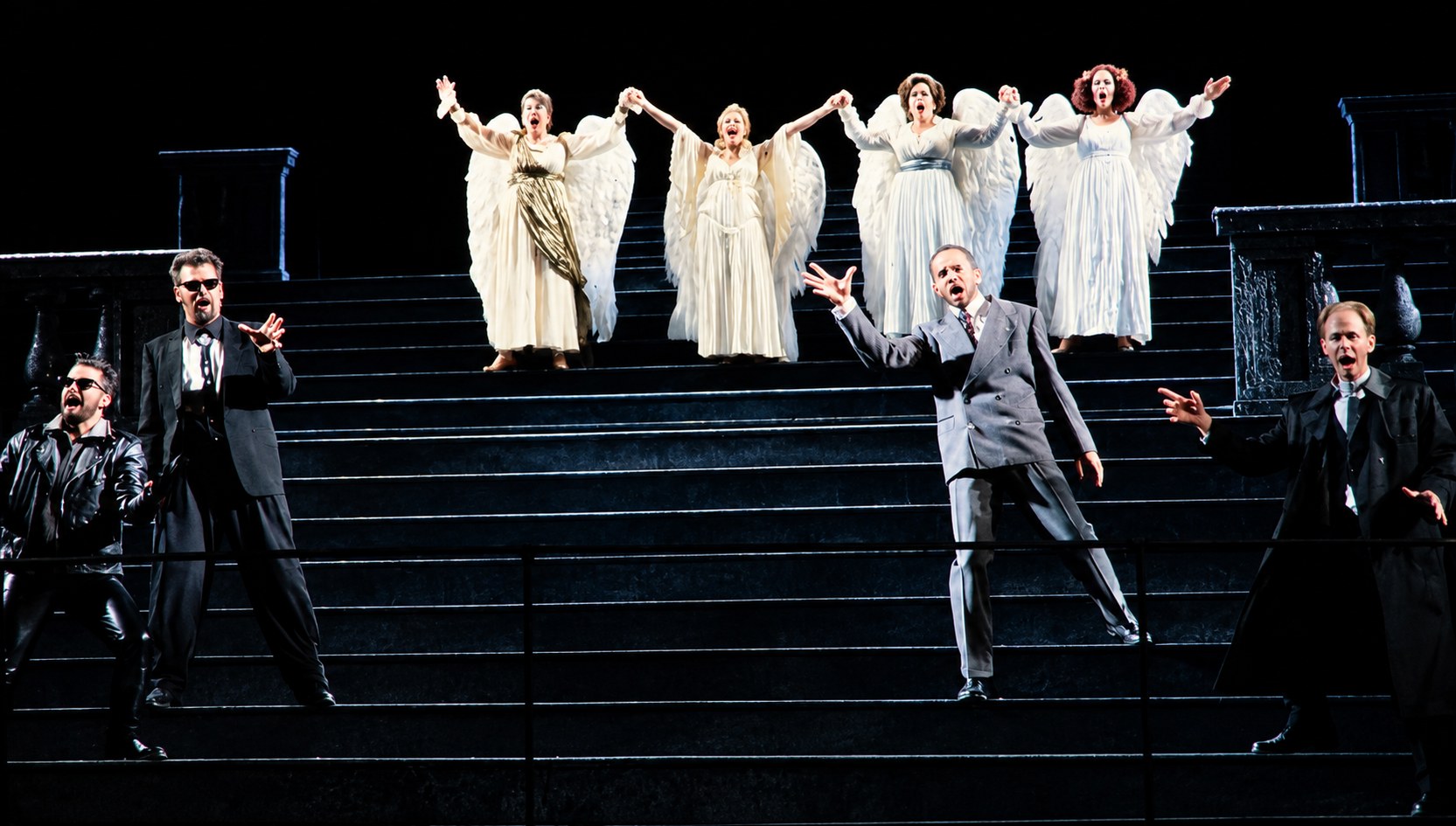 White-clad ensemble above performers on the staircase, Falstaff, University of Michigan, costumes by Laura Crow