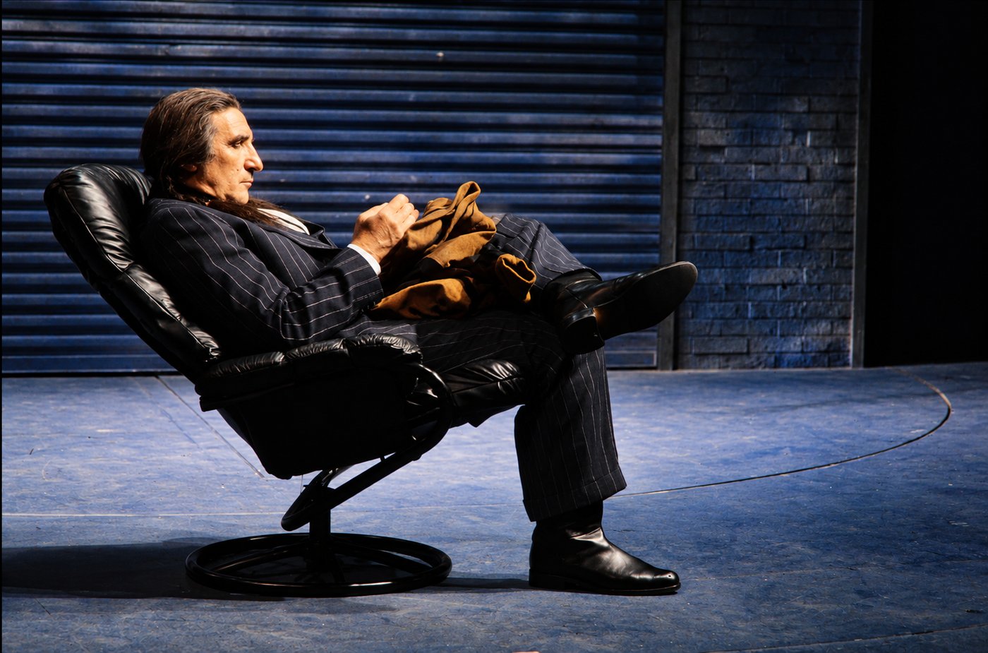 Man reclining in a leather chair, production photo, Robbers, Long Wharf Theatre, costumes by Laura Crow