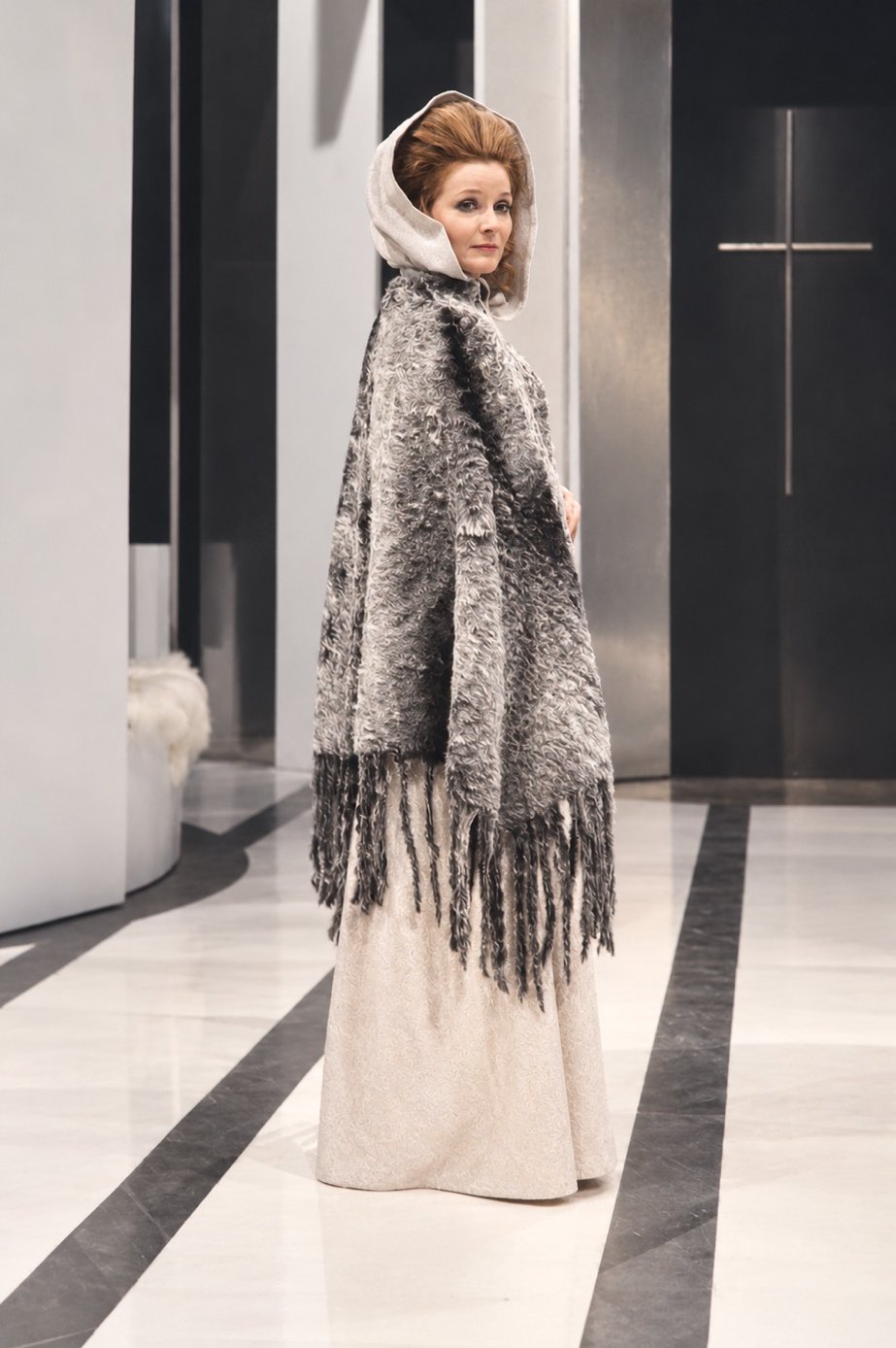 Adrienne Corri in a gray fringed fur cape and hood, Servants and the Snow, Greenwich Theatre, costumes by Laura Crow